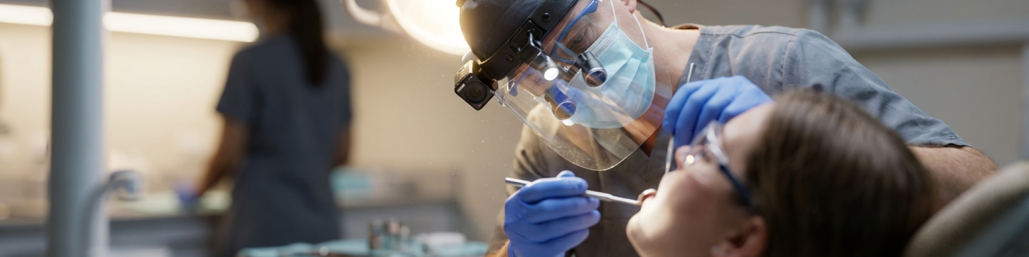 Dentist examining a patients gums for signs of periodontitis.