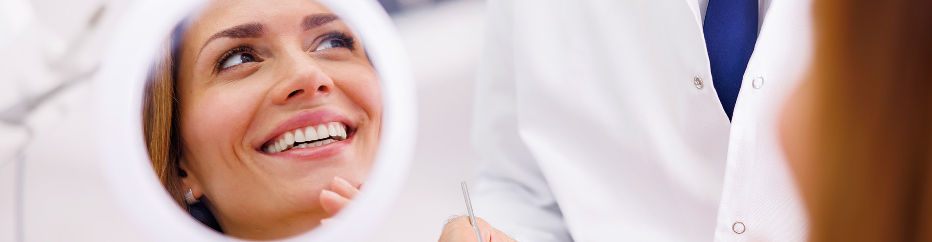 woman smiling reflected in hand mirror