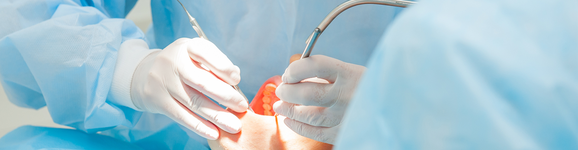 Dental professional performing oral surgery on patient.