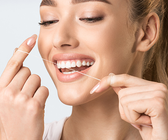 Woman using dental floss