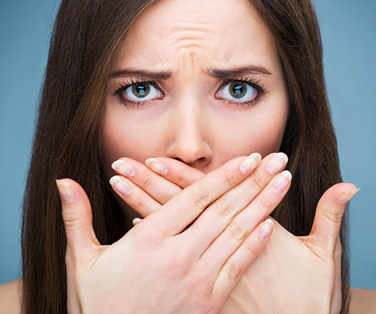 Woman covering her mouth in fear