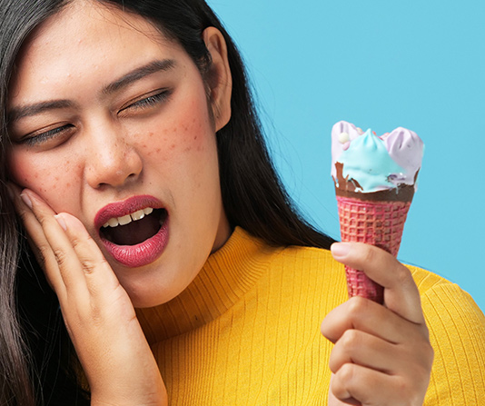 Woman with tooth pain with a ice cream