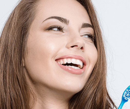 Cosmetic dentistry patient smiling and singing with a toothbrush