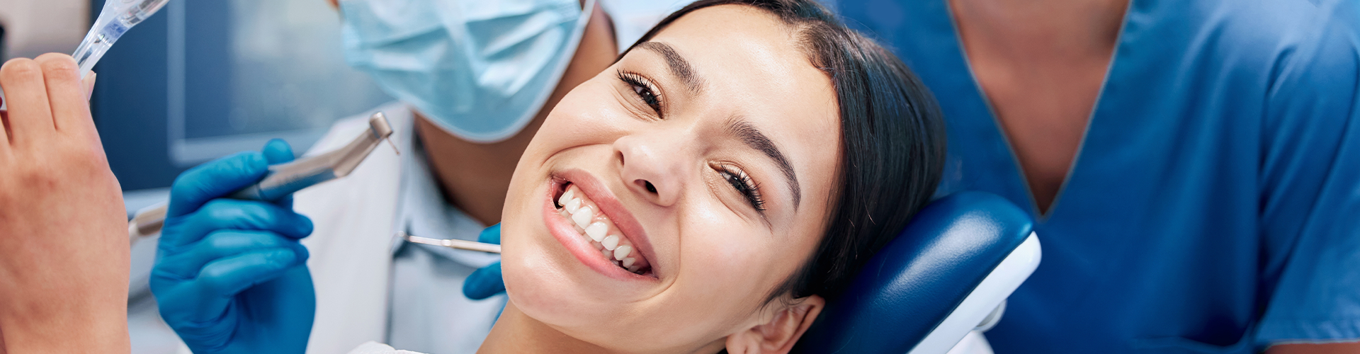 dental staff behind smiling woman