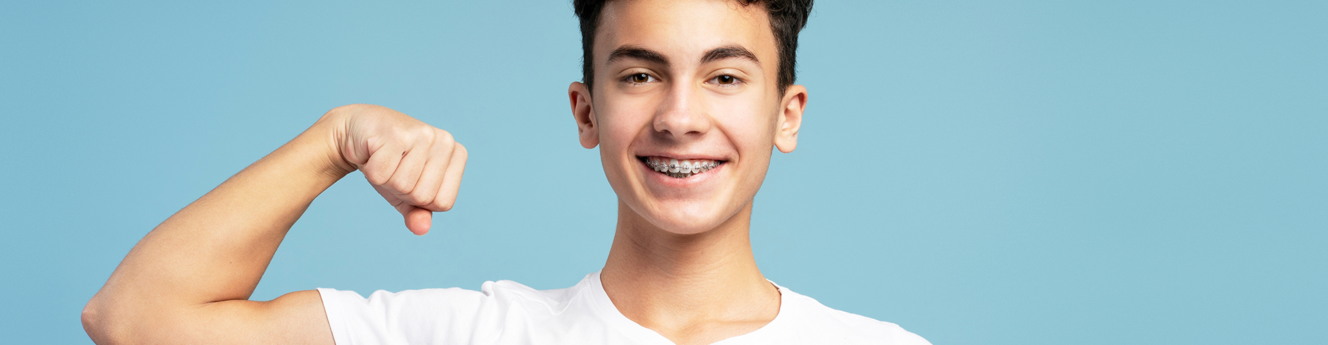 smiling guy with braces flexing his bicep